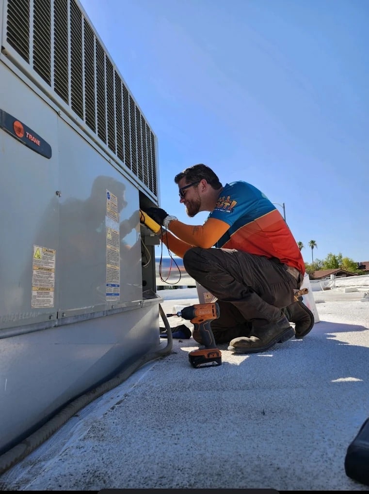 All Out technician working on an air conditioning unit.